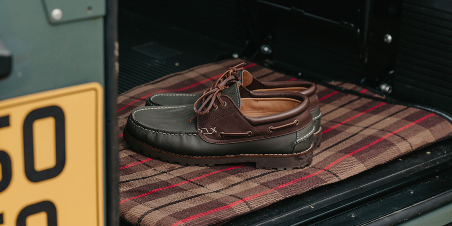 A man sat on a wooden stool, wearing the LANX men's, Brinscall // Tan, moccasin constructed derby shoes.