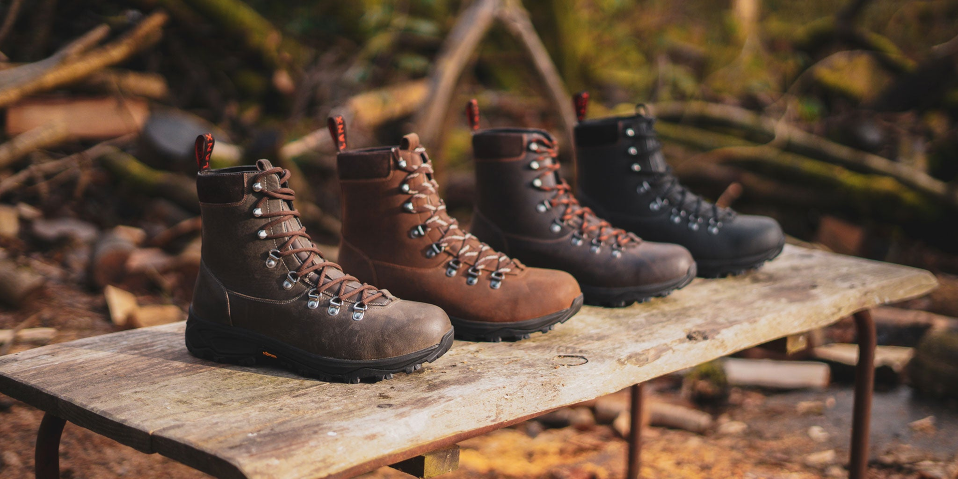 LANX grey, black and brown, derby and chelsea boots on a wooden shoe rack.