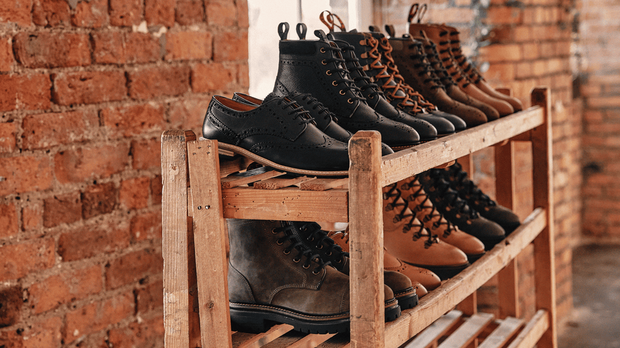 LANX tan, black and brown, lace-to-toe, derby boots and shoes on a wooden shoe rack.
