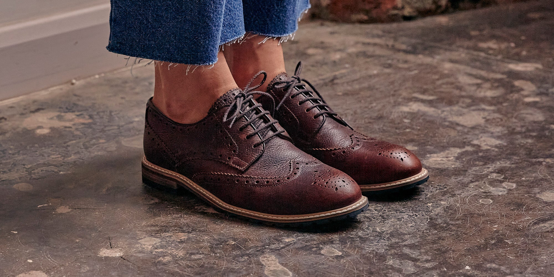 A woman sat on a rug wearing the Calder Anthracite, gum soled, derby shoes.