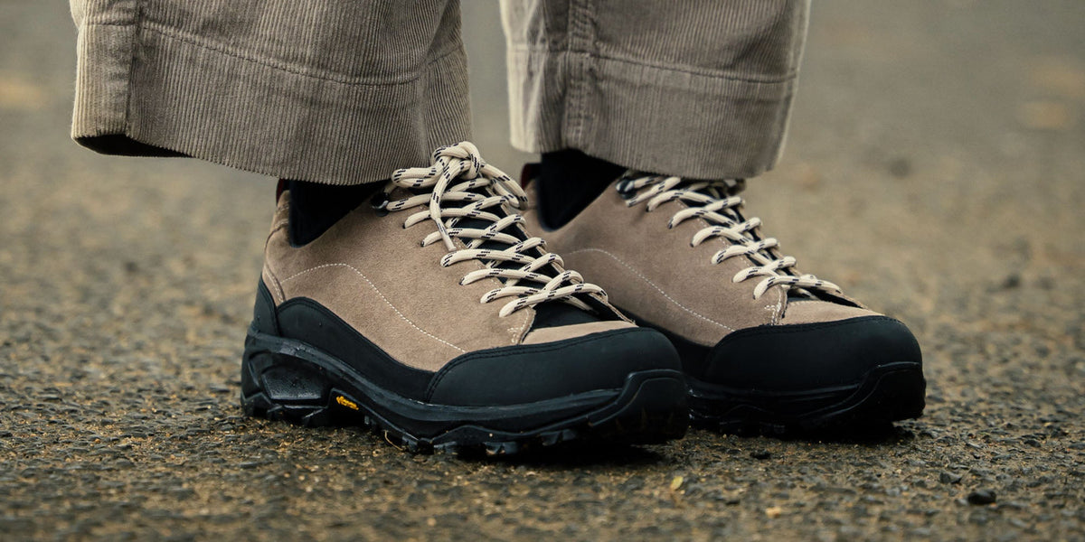 A woman sat on a rug wearing the Calder Anthracite, gum soled, derby shoes.